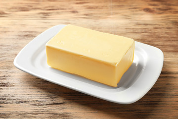 Dish with fresh butter on wooden table