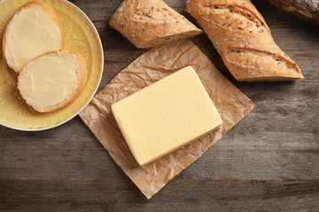 Composition with butter and bread on wooden background