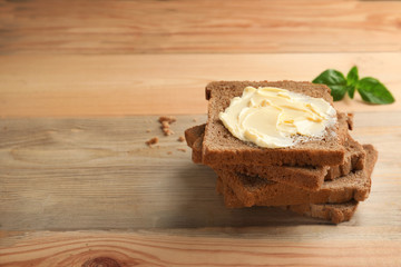 Rye bread with butter on wooden background