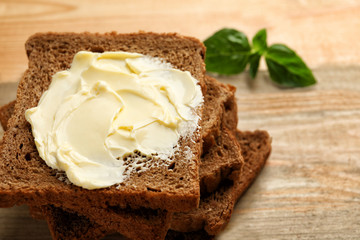 Rye bread with butter on wooden background