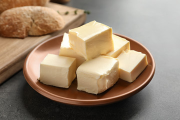 Plate with cubes of butter on table