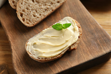 Slice of bread with butter on wooden board