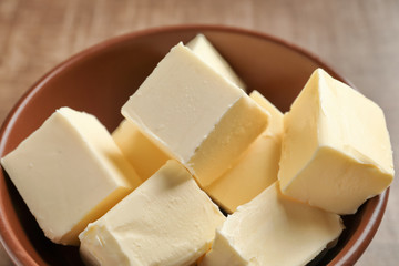 Fototapeta na wymiar Bowl with cubes of butter on table, closeup