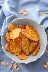 Bowl with yummy sweet potato chips on table