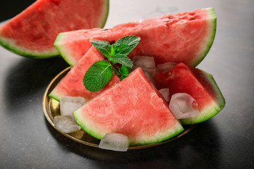 Plate with tasty sliced watermelon on table