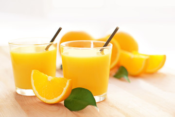 Glasses with yummy fresh orange juice on wooden table
