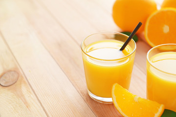 Glasses with yummy fresh orange juice on wooden table