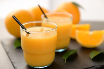 Glasses of fresh orange juice on slate plate