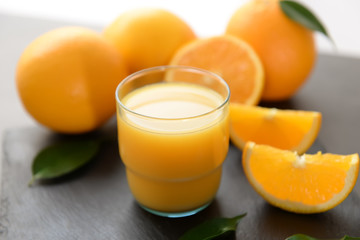 Glass of fresh orange juice on table