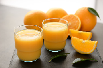 Naklejka na ściany i meble Glasses of fresh orange juice on slate plate