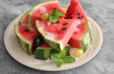 Plate with tasty sliced watermelon on table