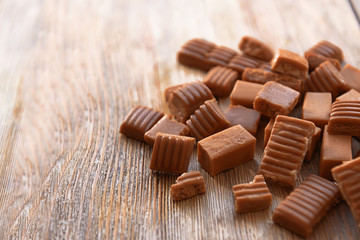 Tasty caramel candies on wooden table