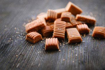 Tasty caramel candies on wooden table