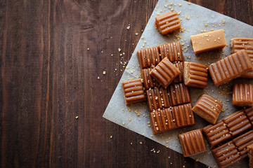 Tasty caramel candies on wooden table