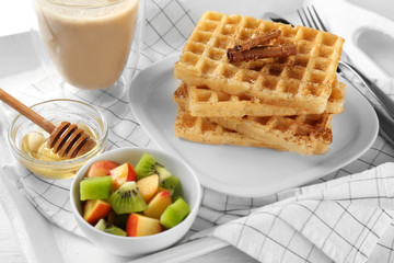 Plate with delicious cinnamon waffles on tray