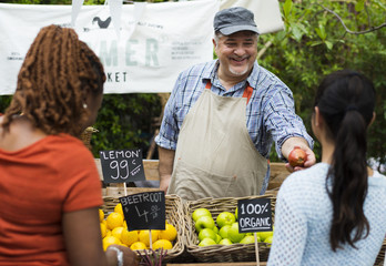 Greengrocer selling organic fresh agricultural product at farmer market