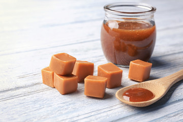 Composition with tasty caramel candies on wooden background