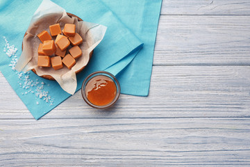 Composition with tasty caramel candies on wooden background