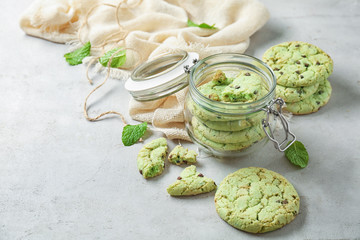 Jar with mint chocolate chip cookies on table
