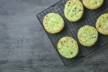 Baking grid with mint chocolate chip cookies on wooden table