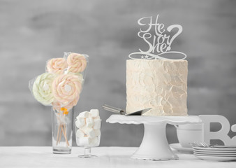 Stand with delicious cake for baby shower party on table
