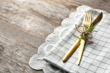 Cutlery with floral decor on wooden background