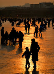 Family playing on frozen lake.