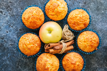 Homemade apple cheese muffins on a wire rack. Blue stone background. Seasonal baking.