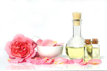 rose oil.  Organic pure natural rose oil in a glass bottle and fresh flowers terry rose and petals...