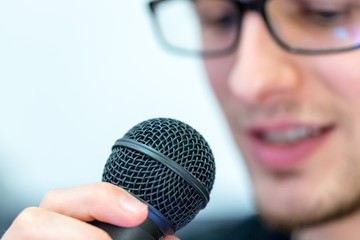 Junger Mann mit Mikrofon, Vortrag
