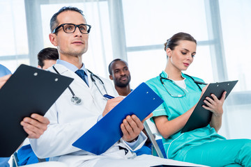 multiethnic group of doctors with clipboards