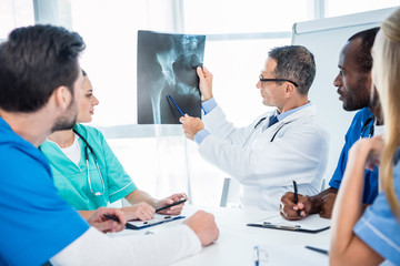 Obraz premium team of doctors looking at x-ray scan