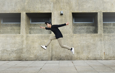 Asian guy midair jumpshot outdoors