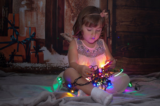 Boy and girl sitting on the floor and playing with Christmas light