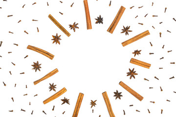 Cinnamon sticks, anise stars and cloves background. Spices for baking or mulled wine. White...