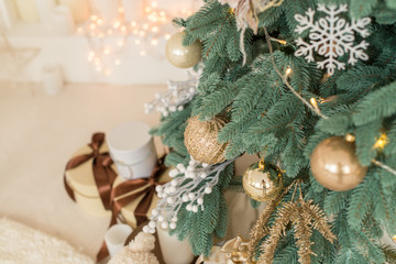 Christmas tree with balls, garlands, in gold colors. The concept of Christmas and happy new year. Xmas present