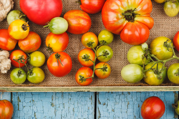 Set of ripe tomatoes in the wooden tray