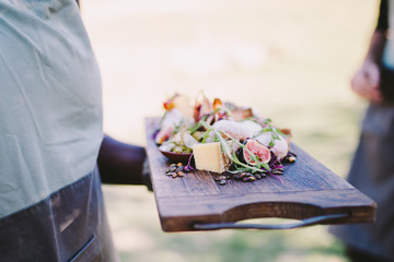 Waiter serving cheese platter in restaurant
