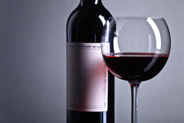 Bottle and glass of red wine .
