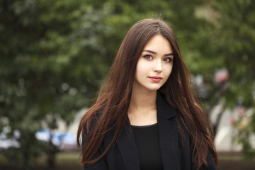 Young beautiful brunette girl in the autumn park