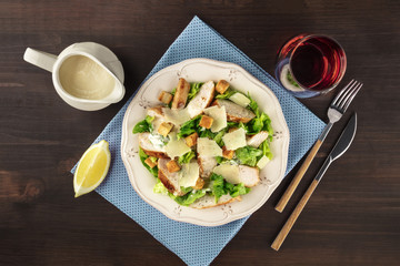 Chicken Caesar salad on rustic background with copyspace