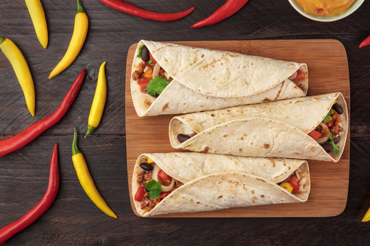 Mexican burritos with cheese salsa, and chili peppers