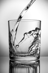 Fresh water pours into an empty glass.