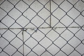 Hazard Prevention By building a metal barbed wire fence. The background is a wall of concrete blocks, Dark edge concept
