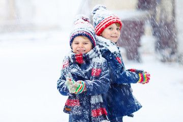 Happy children having fun with snow in winter