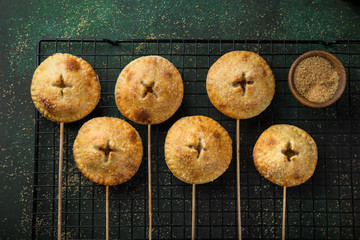 apple pie pops on dark green background.