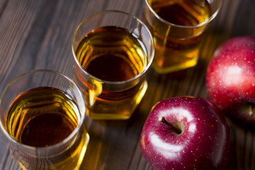 red Apple with Apple juice on a wooden table close up