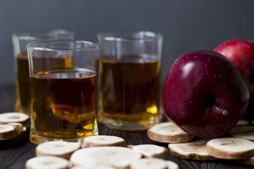 red Apple with Apple juice on a wooden table close up