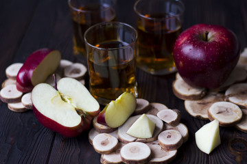 red Apple with Apple juice on a wooden table close up