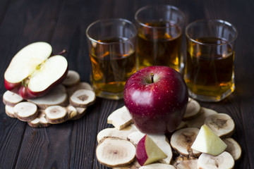 red Apple with Apple juice on a wooden table close up